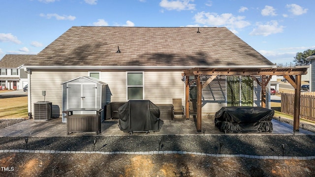 back of property with a pergola, a patio, central AC unit, and a storage unit