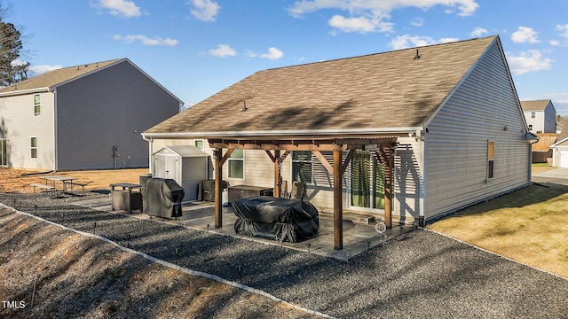 back of house with a storage shed, a pergola, and a patio