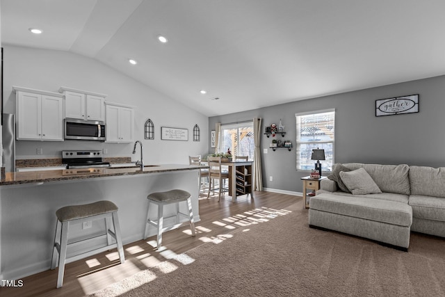 living room featuring dark hardwood / wood-style flooring, lofted ceiling, and sink