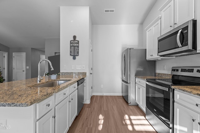 kitchen with white cabinets, stone countertops, sink, and stainless steel appliances