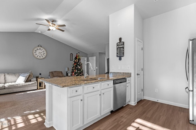 kitchen with stone counters, white cabinets, sink, appliances with stainless steel finishes, and kitchen peninsula