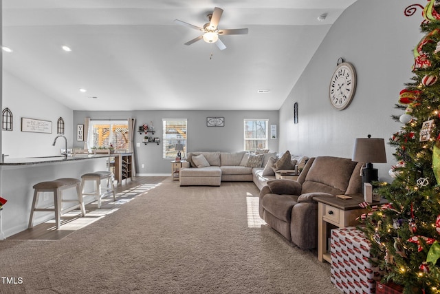 living room featuring carpet, ceiling fan, lofted ceiling, and sink