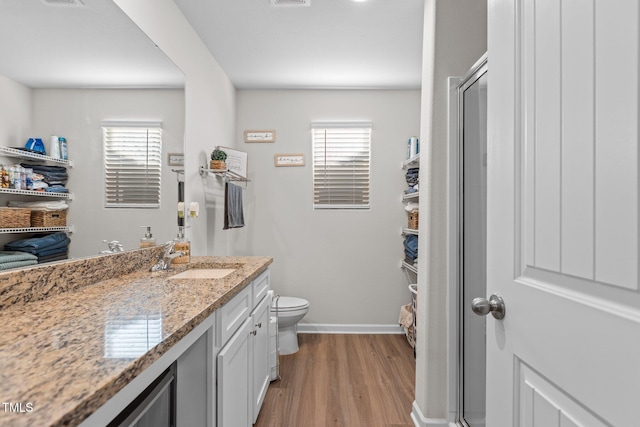 bathroom featuring plenty of natural light, vanity, hardwood / wood-style floors, and toilet