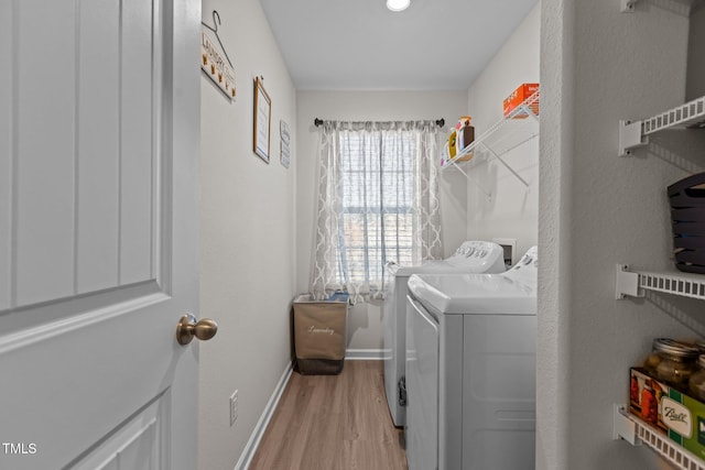 washroom with washer and dryer and light hardwood / wood-style flooring