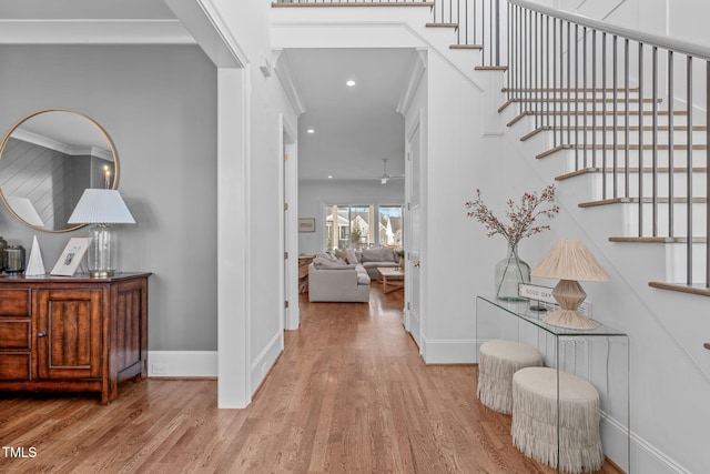 hallway with crown molding and light hardwood / wood-style floors