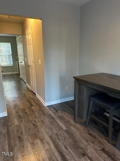 unfurnished dining area featuring dark wood-type flooring