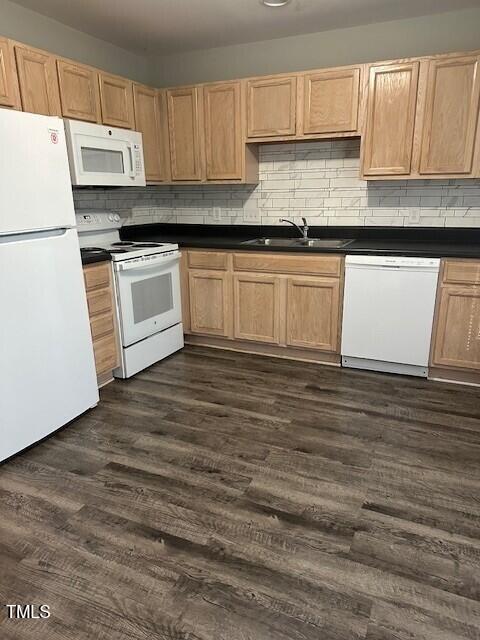 kitchen featuring sink, light brown cabinets, dark wood-type flooring, white appliances, and decorative backsplash