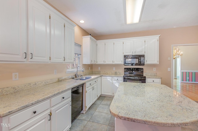 kitchen featuring white cabinetry, sink, a kitchen island, and black appliances