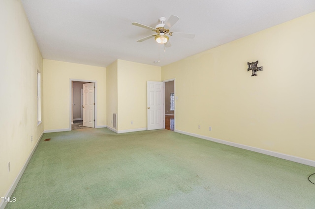 unfurnished room with ceiling fan and carpet