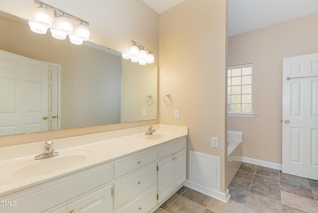 bathroom with a bathing tub, vanity, and an inviting chandelier