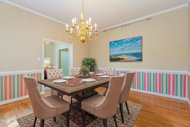 dining space with crown molding, a notable chandelier, and hardwood / wood-style flooring