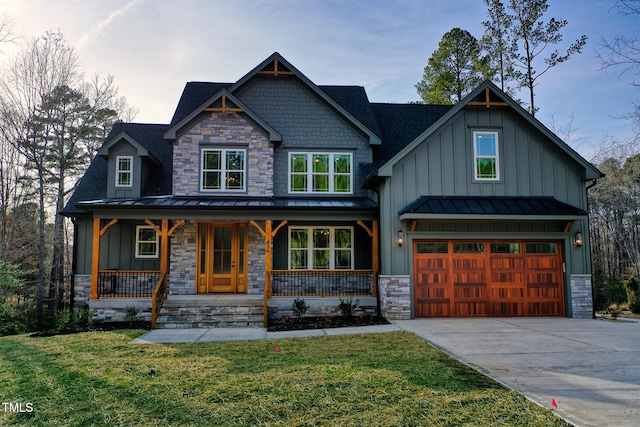 craftsman inspired home featuring board and batten siding, covered porch, an attached garage, and a standing seam roof