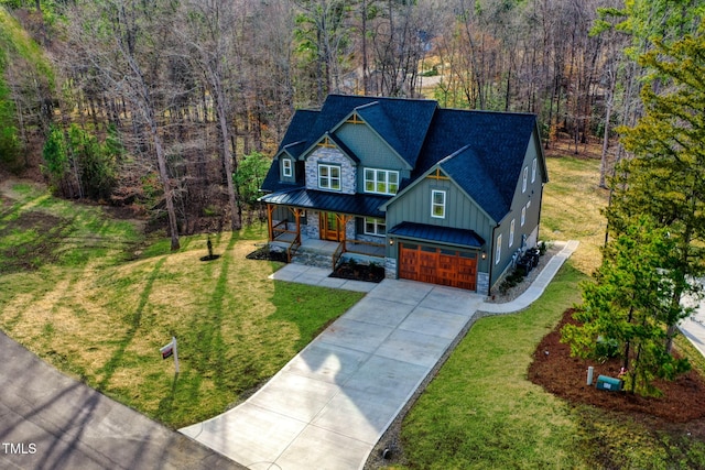 view of front of home featuring a standing seam roof, a front lawn, covered porch, and board and batten siding