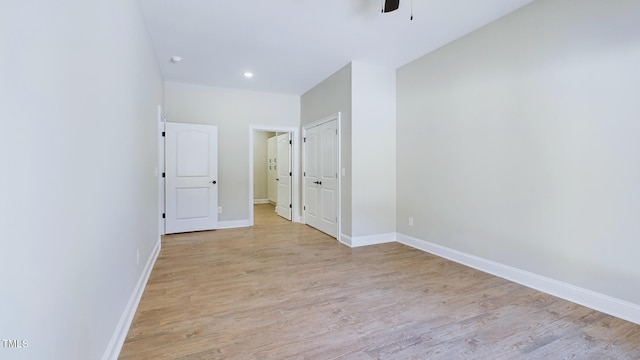 empty room with ceiling fan, recessed lighting, light wood-style flooring, and baseboards