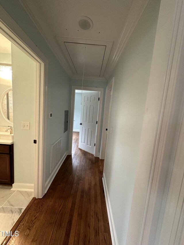 hall with crown molding, wood-type flooring, and sink