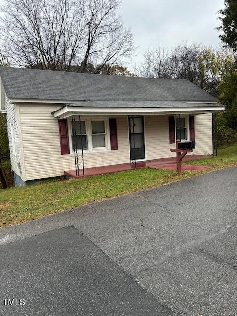 view of front of house with covered porch and a front lawn