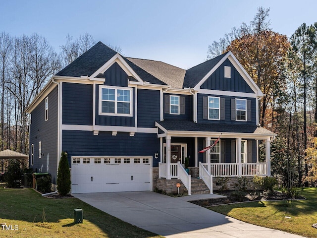 view of front of house featuring a porch, a front yard, and a garage