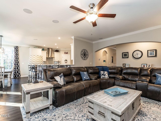 living room with wood-type flooring, ceiling fan, and crown molding