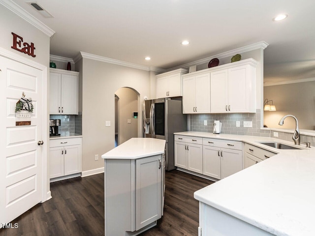 kitchen featuring dark hardwood / wood-style floors, white cabinetry, ornamental molding, and sink