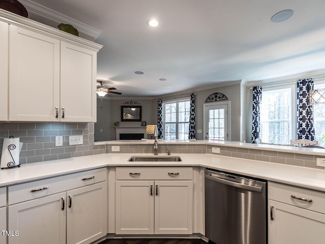 kitchen featuring kitchen peninsula, stainless steel dishwasher, plenty of natural light, and sink