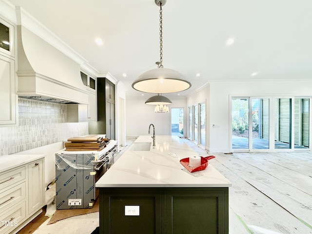 kitchen featuring a large island, decorative light fixtures, sink, tasteful backsplash, and light stone counters