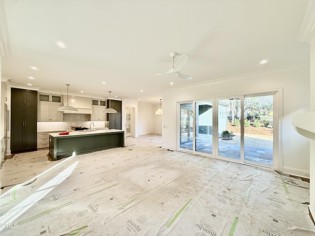 unfurnished living room with ceiling fan, sink, and ornamental molding