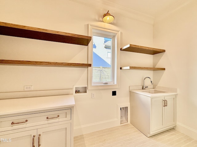 clothes washing area with sink, cabinets, and washer hookup