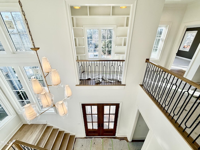 interior space featuring french doors, a wealth of natural light, and a high ceiling