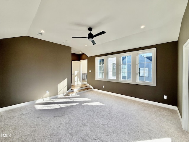 spare room with ceiling fan, light carpet, and lofted ceiling