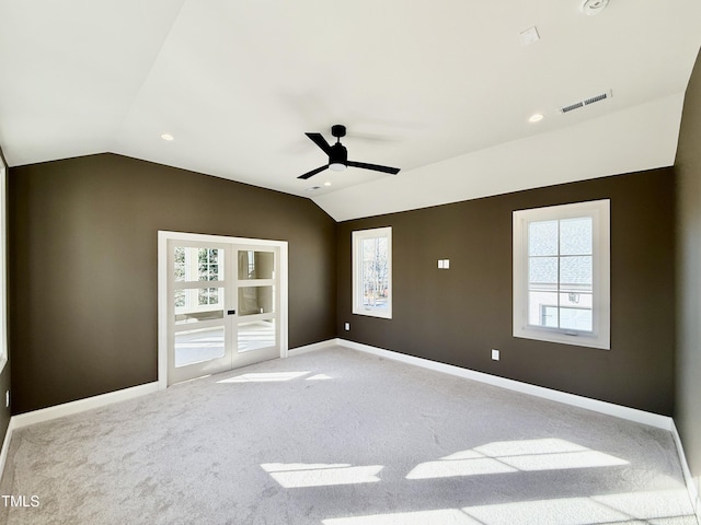 unfurnished bedroom with multiple windows, vaulted ceiling, and carpet flooring