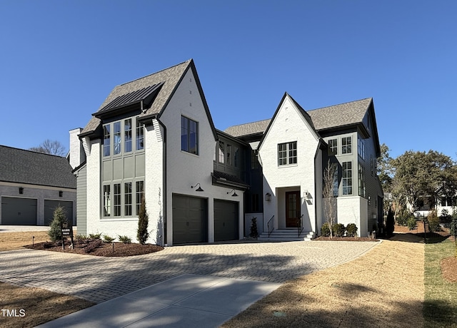 view of front of property with an attached garage, decorative driveway, and brick siding