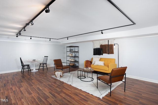 living area with dark hardwood / wood-style floors and track lighting