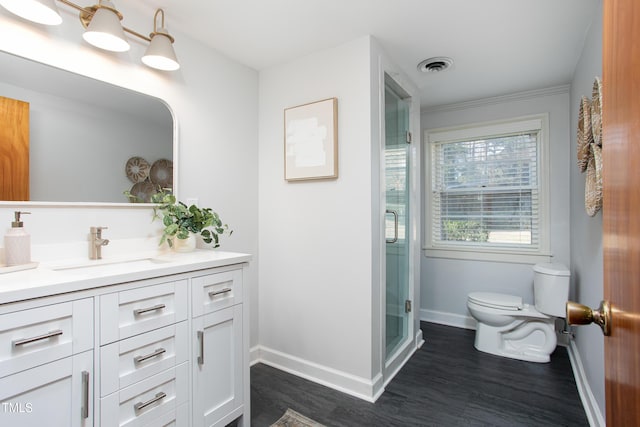 bathroom with hardwood / wood-style flooring, vanity, toilet, and walk in shower