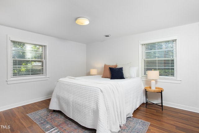 bedroom with dark hardwood / wood-style flooring