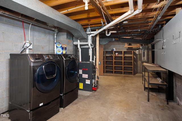 basement with heating unit, electric panel, and washer and dryer