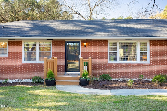 property entrance with a lawn