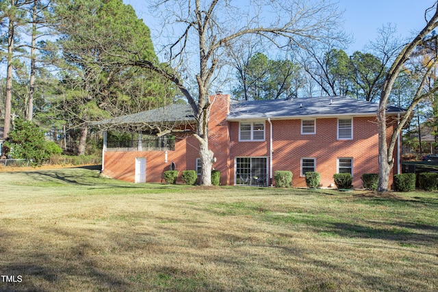 rear view of house featuring a lawn