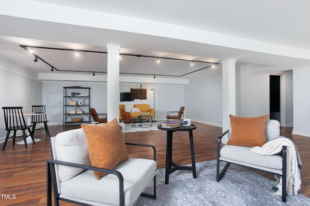 sitting room with decorative columns, dark wood-type flooring, and track lighting