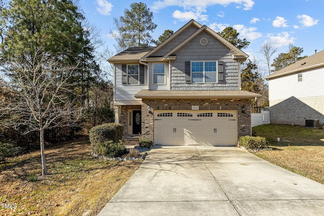 view of front of house with a front yard, central AC unit, and a garage