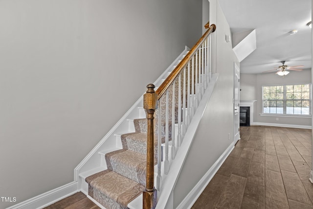 stairway with hardwood / wood-style flooring and ceiling fan