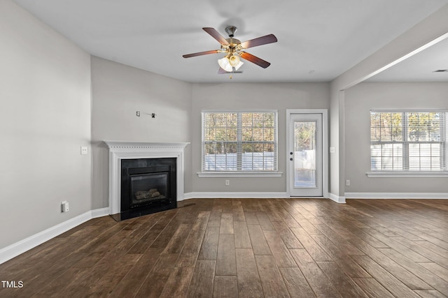 unfurnished living room with ceiling fan and dark wood-type flooring