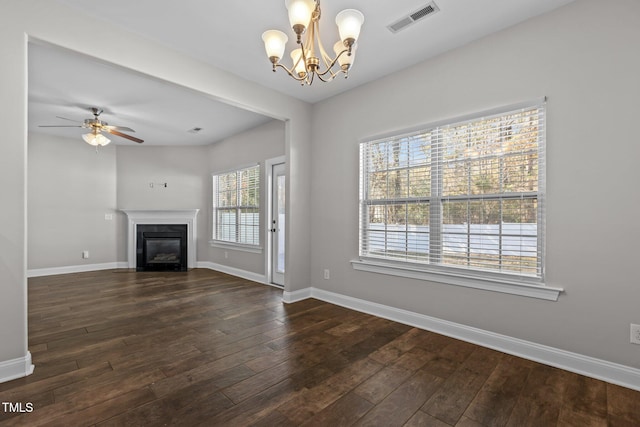 unfurnished living room featuring dark wood-type flooring and ceiling fan with notable chandelier