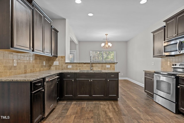 kitchen featuring hanging light fixtures, sink, dark hardwood / wood-style floors, appliances with stainless steel finishes, and a chandelier