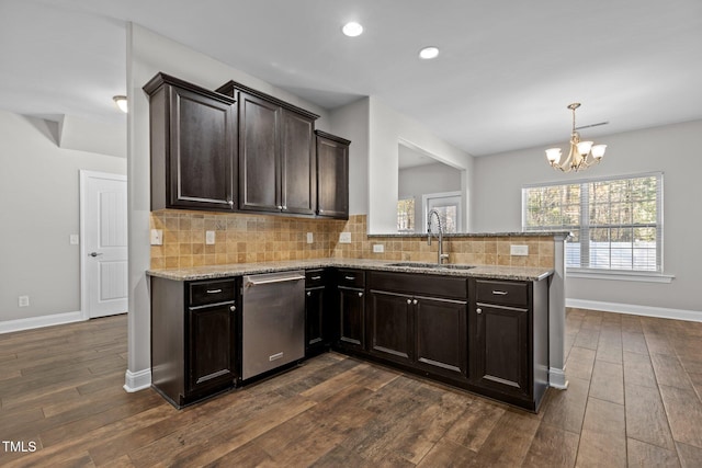 kitchen featuring kitchen peninsula, dark hardwood / wood-style floors, an inviting chandelier, and sink