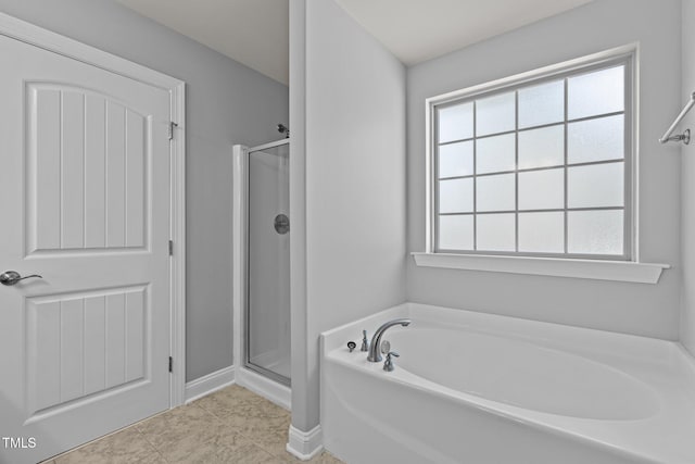 bathroom featuring tile patterned flooring and shower with separate bathtub