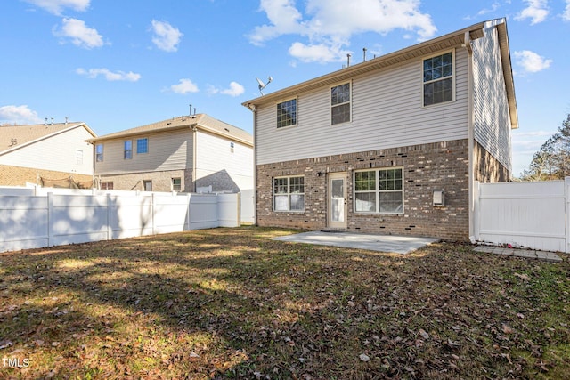 rear view of house with a lawn and a patio area