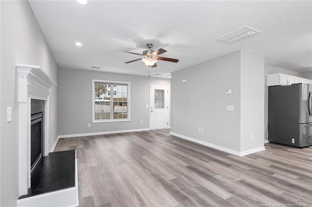 unfurnished living room featuring light hardwood / wood-style flooring and ceiling fan