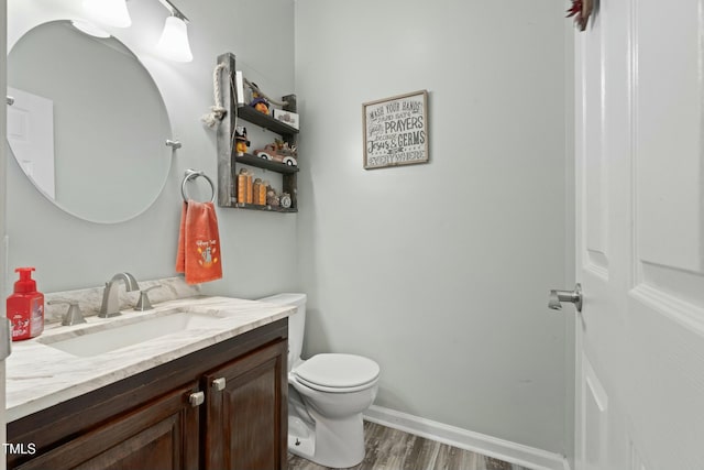 bathroom with wood-type flooring, vanity, and toilet