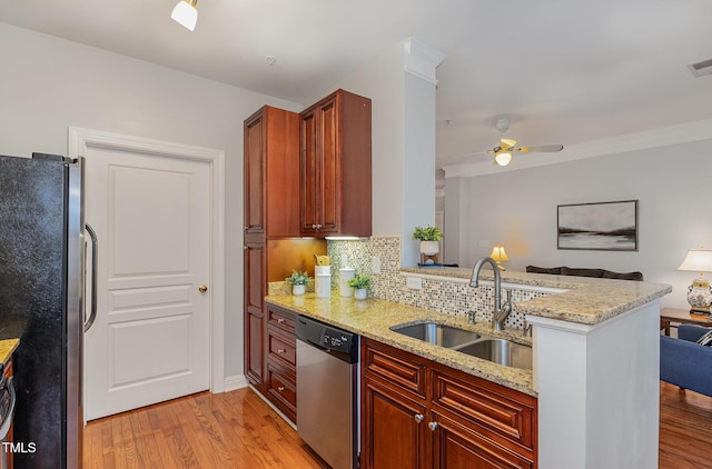 kitchen featuring kitchen peninsula, light stone counters, sink, and stainless steel appliances