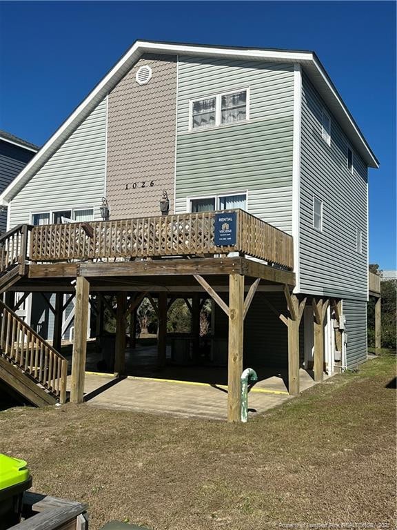 rear view of house featuring a patio area, a yard, and a wooden deck